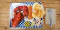 Freshly cooked whole lobster with potato chips, cole slaw and melted butter Royalty Free Stock Photo