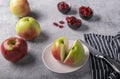 A freshly cut appetizing red apple on a plate, next to whole big beautiful apples, a knife on a napkin. Royalty Free Stock Photo