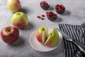 Freshly cut appetizing red apple on a plate, next to whole large beautiful apples, a knife on a napkin. Royalty Free Stock Photo