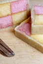 Freshly cut Battenberg Cake with knife. Pink and yellow sponge covered in marzipan Royalty Free Stock Photo