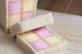 Freshly cut Battenberg Cake with pink and yellow sponge covered in marzipan Royalty Free Stock Photo