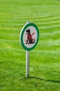 Freshly cut green grass with round sign forbidding dogs Royalty Free Stock Photo