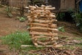 Freshly cut stacked firewood in front of a wooden house. Chopped firewood used for cooking in an outdoor kitchen.