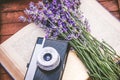 Freshly cutted lavender flowers and a vintage photo camera over an open book.Wooden background.