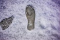 On the freshly fallen snow, the imprint of the sole of winter shoes with a large pattern that ensures safe movement on snow-