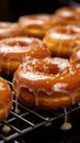 Freshly fried dozen glazed donuts on a baking sheet