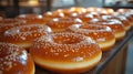 Freshly glazed donuts displayed in a modern bakery setting with sesame toppings Royalty Free Stock Photo