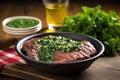 freshly grilled asado steak beside a chimichurri sauce bowl