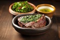 freshly grilled asado steak beside a chimichurri sauce bowl