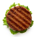 Freshly grilled plant based burger patty on bun with lettuce and sauce isolated on white. Top view