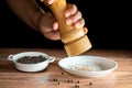 Freshly ground black peppercorns and whole black peppercorns in a white ceramic plate Royalty Free Stock Photo