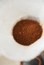 Freshly ground coffee in paper filter close up top view. Alternative manual brewing