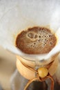 Coffee blooming in paper filter top view. Alternative manual brewing Royalty Free Stock Photo
