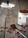 Freshly ground coffee in a spoon, coffee grains are scattered nearby on a brown wooden table. Making fresh aromatic espresso la Royalty Free Stock Photo