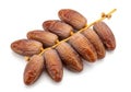 Freshly harvested dates hanging on a string against a plain background Royalty Free Stock Photo