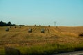 The freshly harvested grain field. Field of freshly bales of hay with beautiful sunset Royalty Free Stock Photo