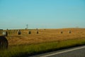 The freshly harvested grain field. Field of freshly bales of hay with beautiful sunset Royalty Free Stock Photo