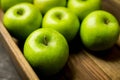 Freshly harvested green apples in the wooden crate. Selective focus Royalty Free Stock Photo