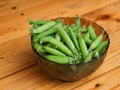 Freshly harvested green peas in a glass bowl on a wooden table Royalty Free Stock Photo