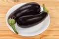 Freshly harvested purple eggplants on dish on the rustic table Royalty Free Stock Photo