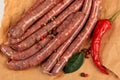 Freshly home made raw breed butchers sausages in skins with spices on cooking paper. Royalty Free Stock Photo