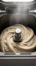 Freshly kneaded dough swirling in bread maker with steam signaling baking process inside kitchen appliance Royalty Free Stock Photo