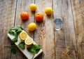 Freshly lemons and oranges with glass water on wooden boards