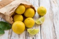 Freshly lemons in paper bag on white wooden table