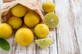 Freshly lemons in paper bag on white wooden table