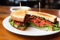 freshly-made blt bacon, lettuce, tomato sandwich beside a green salad Royalty Free Stock Photo