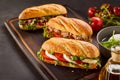 Freshly made gourmet sandwiches on wooden tray Royalty Free Stock Photo