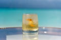 Freshly made icy tropical cocktail on the glass table at the beach with ocean Royalty Free Stock Photo