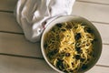 Fresh linguine in a bowl with garlic, olive oil, black olives, capers and fresh basil. Room for copy.