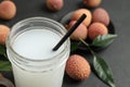 Freshly made lychee juice on grey table, closeup. Space for text