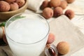 Freshly made lychee juice on white wooden table, closeup. Space for text