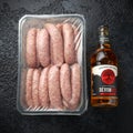 Freshly made raw butchers sausages in skins with Sanford orchards apple cider, Devon, United Kingdom, March 20, 2019.