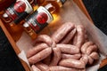 Freshly made raw butchers sausages in skins with Sanford orchards apple cider, Devon, United Kingdom, March 20, 2019.