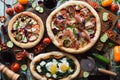 Freshly made yummy pizza party. Flatlay of puffy pizzas with pancetta, aubergines, spinach, eggs, bell pepper and arugula served
