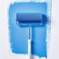 Freshly painted surface showcasing a blue paint roller and vibrant texture on a wall Royalty Free Stock Photo