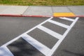 Freshly painted white crosswalk marking leading to a yellow painted ADA sidewalk access in a fire lane Royalty Free Stock Photo