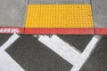 Freshly painted white crosswalk marking leading to a yellow painted ADA sidewalk access in a fire lane Royalty Free Stock Photo