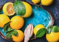 Freshly picked lemons with leaves and pounder in blue plate
