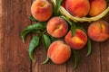 Freshly picked peaches in basket on a brown wooden background. Ripe peaches in basket on wooden table Royalty Free Stock Photo