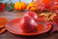 Freshly picked red pears on the orange plate. Autumn harvest concept