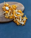 Freshly picked yellow golden chanterelles, cleaned, sliced on cutting board.