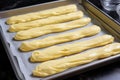 freshly piped eclair dough ready to be baked on a pan
