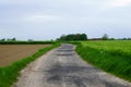 Freshly plowed field and typical winding gravel road in the flemish ardennes. Royalty Free Stock Photo