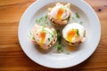freshly poached eggs atop muffins, pre-sauce for a deconstructed look