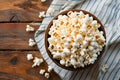 Freshly popped popcorn in bowl on rustic wooden table with blue striped cloth Royalty Free Stock Photo