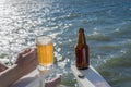 Freshly poured beer in mug on seaside deck with bottle Royalty Free Stock Photo
